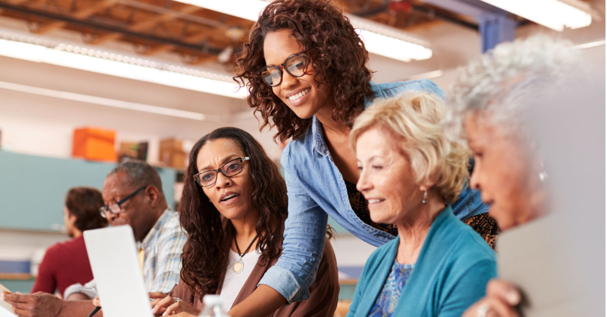 Retirees learning how to use a computer.