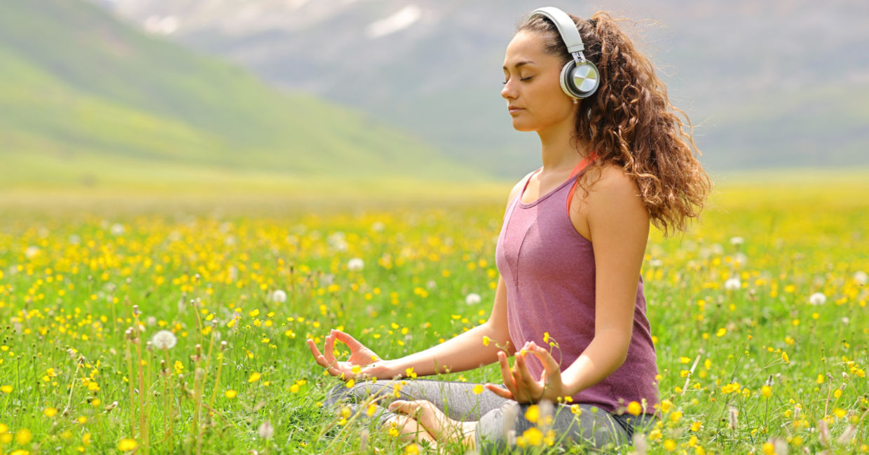 woman listening to guided meditation in nature