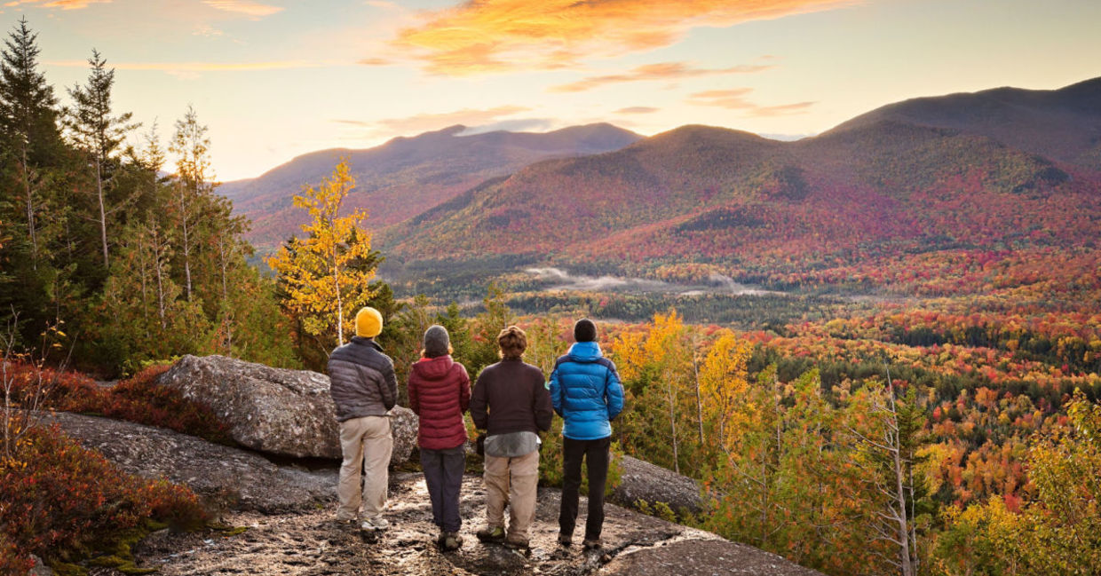 A family hiking at the Adirondacks in late autumn stops to enjoy the view.