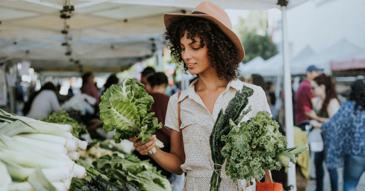 Woman buying kale at a farmers’ market