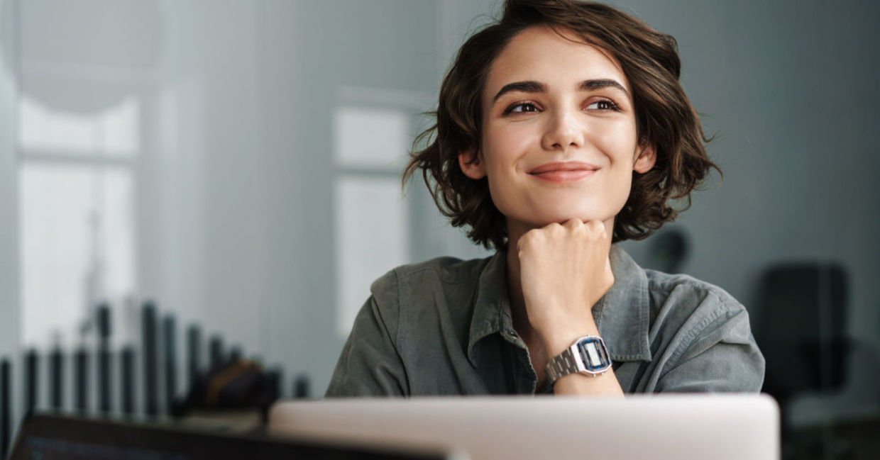 A smiling woman working on her laptop.