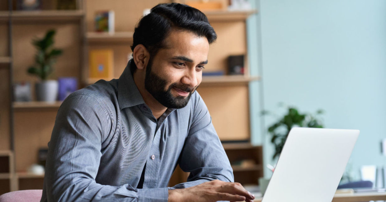 A man gazes down at his laptop, reducing eye strain.