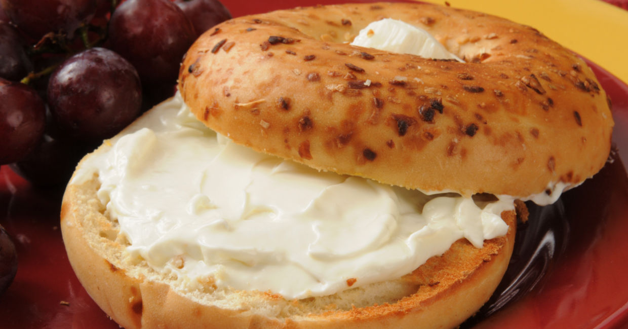 An onion bagel with a smear of plant-based vegan cream cheese.