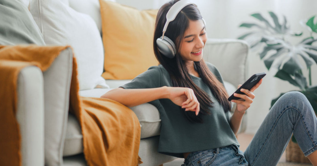 A young girl is happy listening to upbeat music.