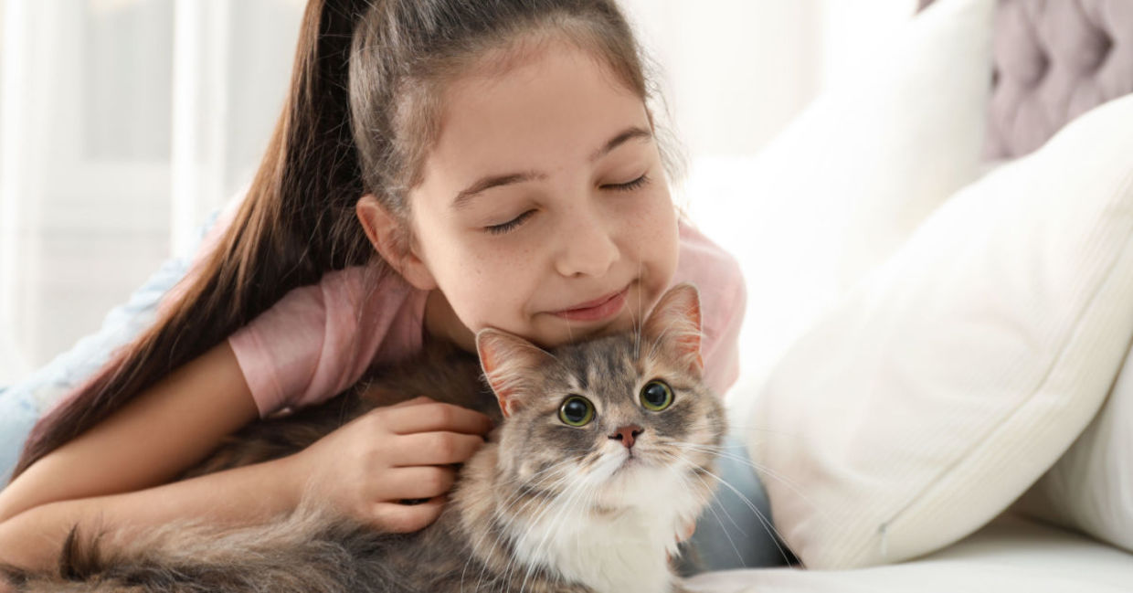 A girl activates oxytocin by hugging her cat.