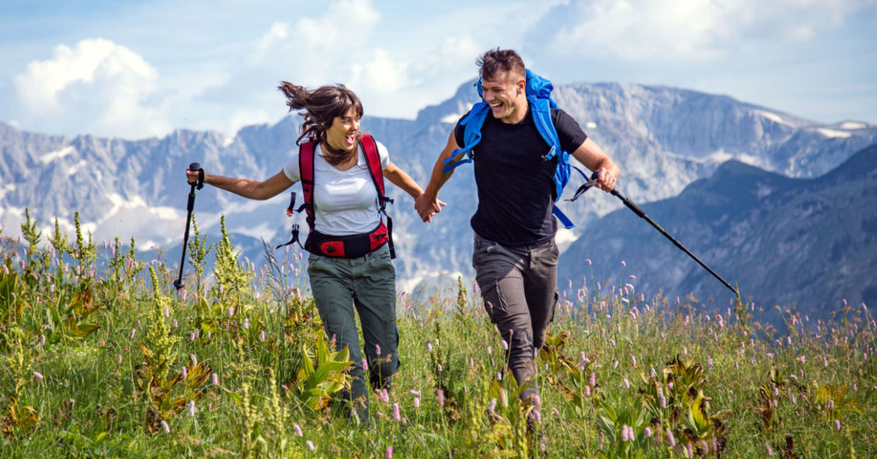 Hikers in a mountain meadow are exploring the world in a sustainable way.