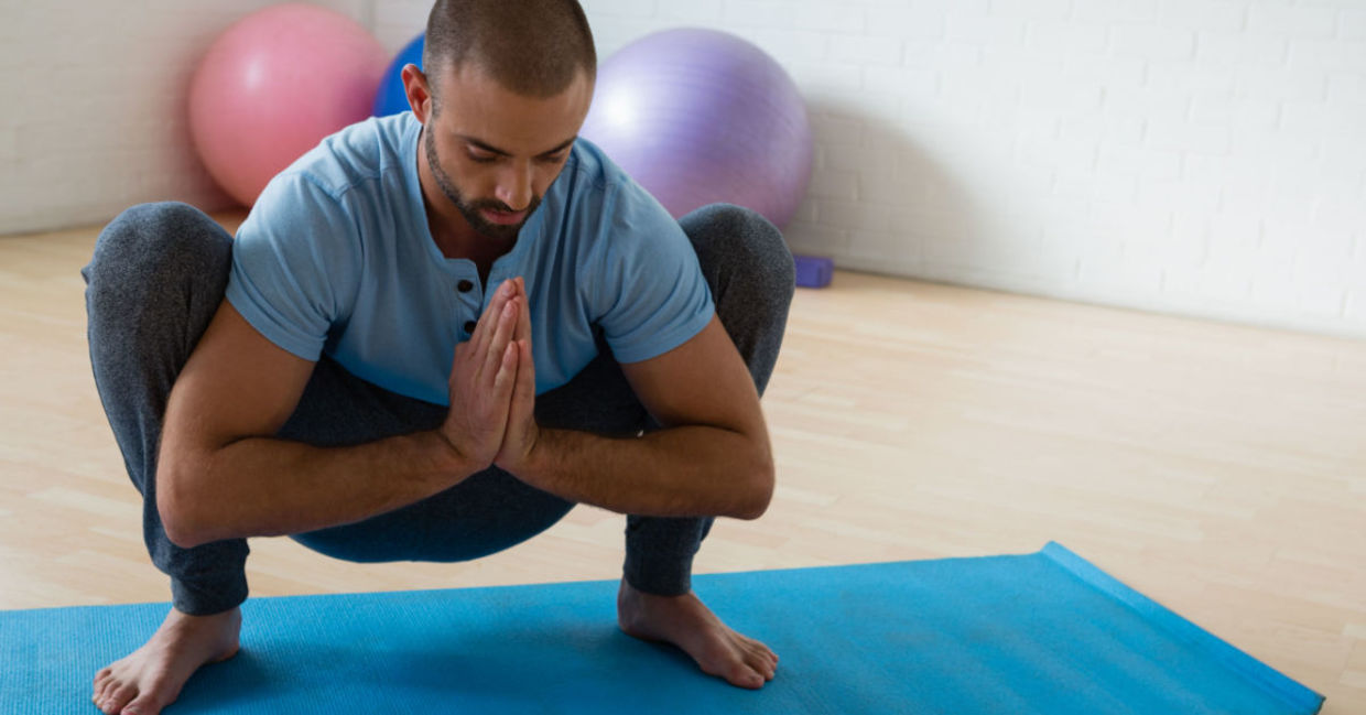 Man in the yogi squat pose.