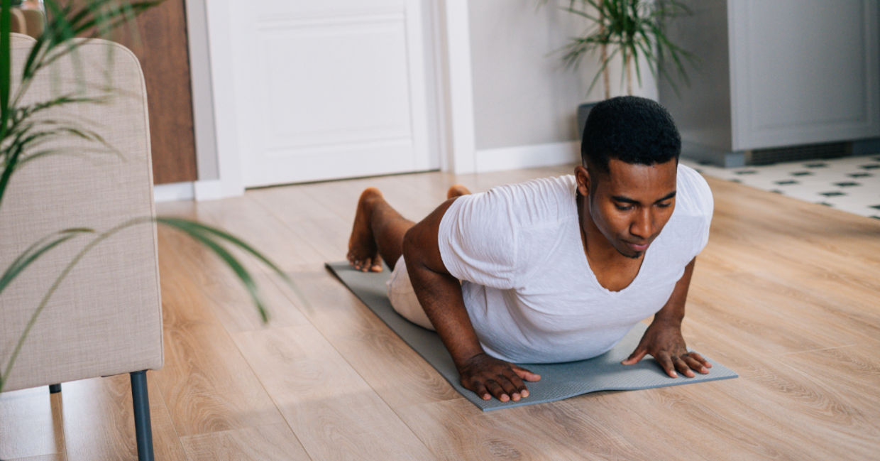 Man doing burpees at home.