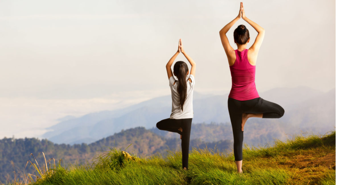 Mother and daughter practicing the tree pose.