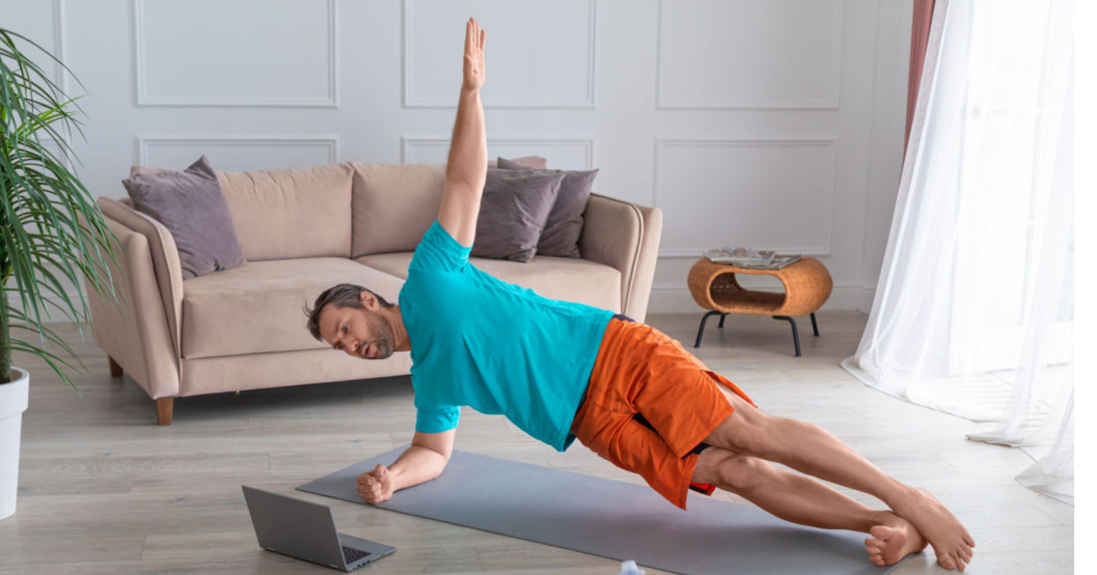 A man doing the side plank pose in a guided yoga session.