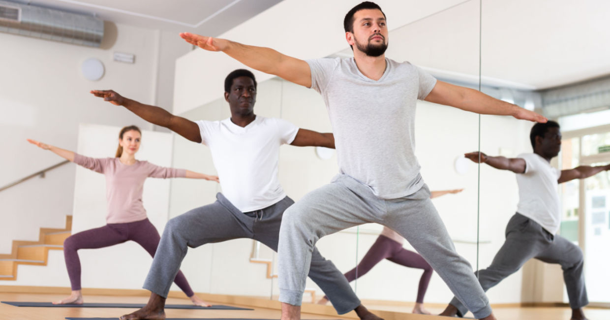 Yoga class in Warrior II pose.