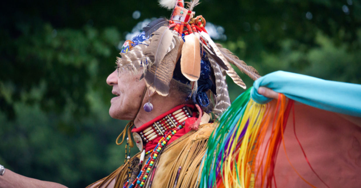 A Native American man from the Pokanoket Wampanoag tribe wearing traditional clothing at a                                   local powwow in Haverhill, Massachusetts, USA.
