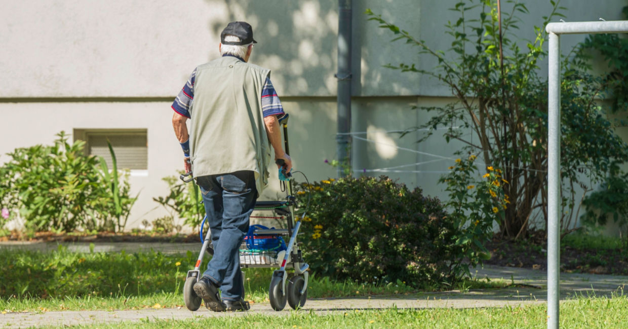 Senior man walking in his yard.