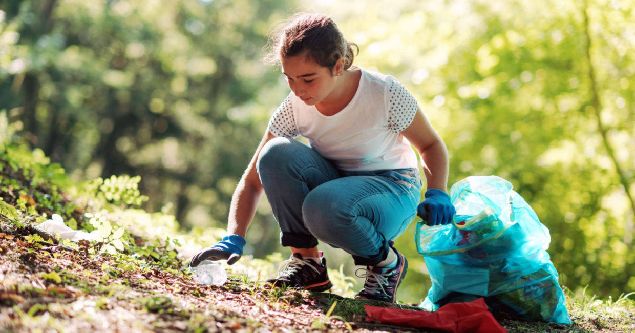 Teenage girl cleaning a community park.