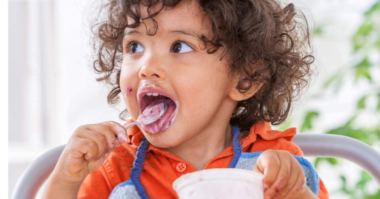 Toddler eating yogurt.