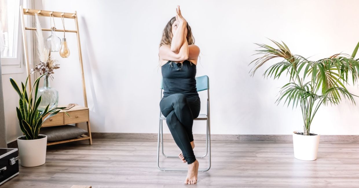 woman in the seated eagle chair yoga pose.