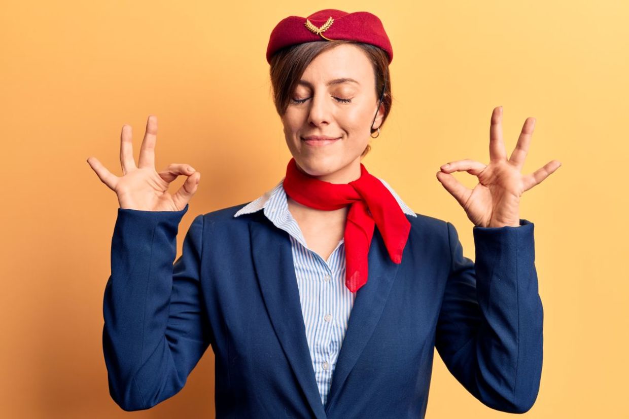A flight attendant leading plane yoga.