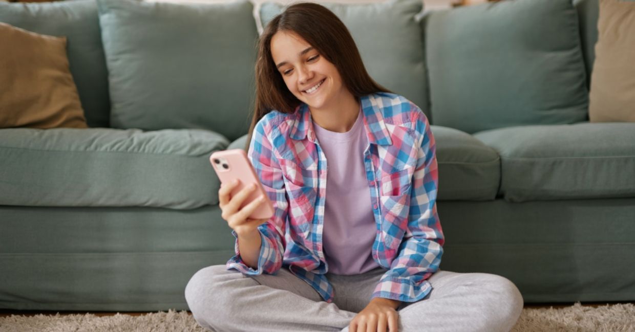A teenage girl using an AI companion on her phone.