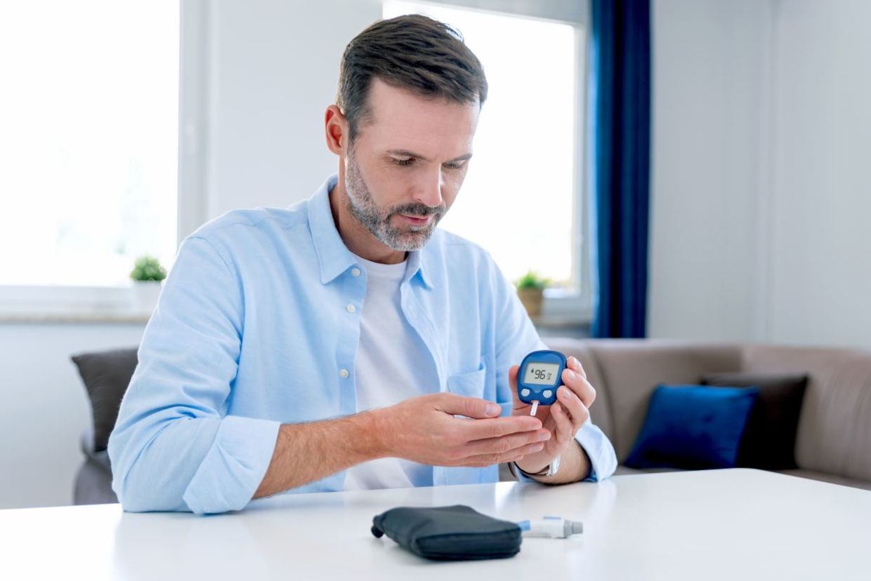 A man checking his blood glucose level.