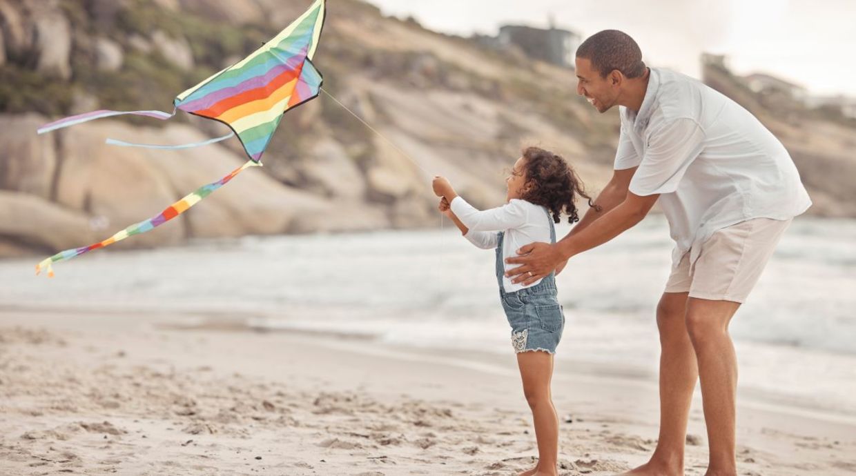 A father and daughter flying a kite.
