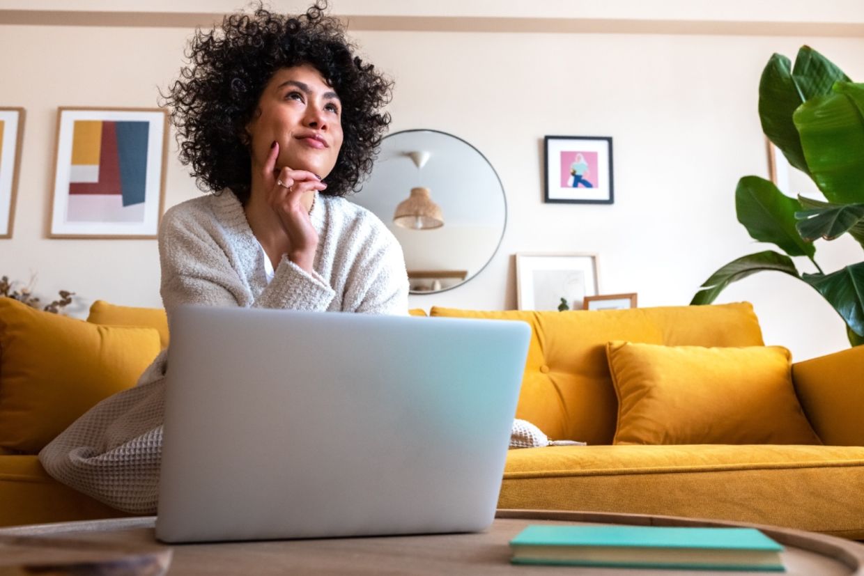 A woman thinking in a living room.