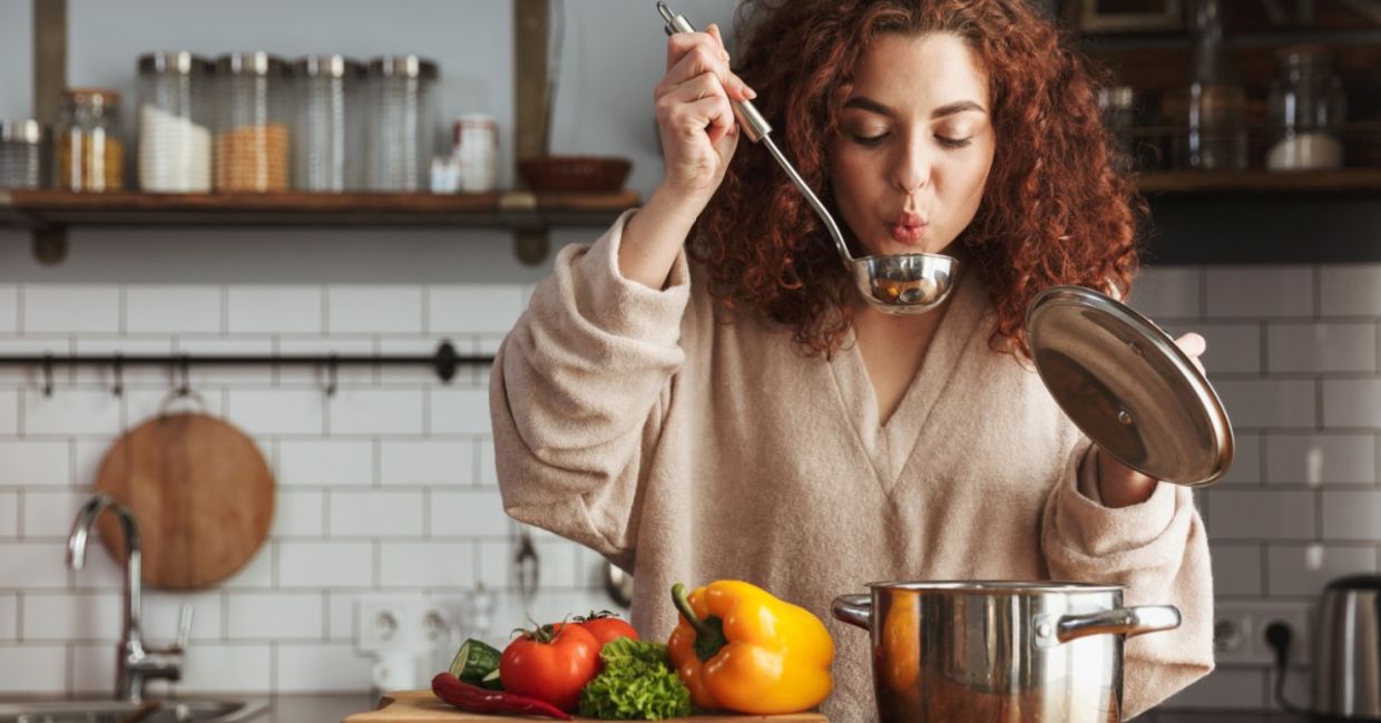 A woman boiling vegetables to make a healthy soup.