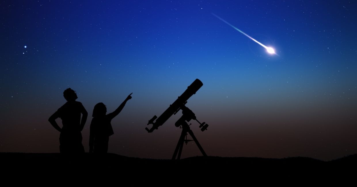 Father and daughter watching a meteor shower.