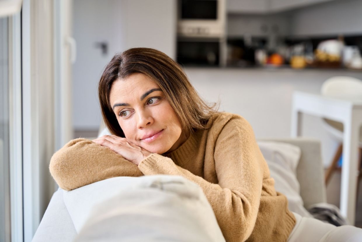 A woman sits on a sofa.