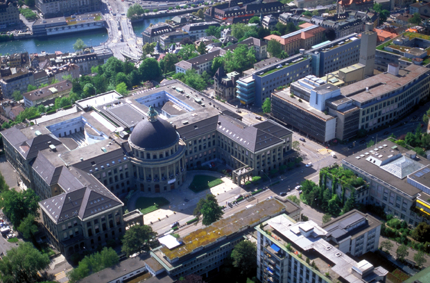 ETH ETH Zurich, Aerial view of a city with a large domed governmental building, mixed historic and modern architecture, green spaces, and a waterway running through the urban landscape