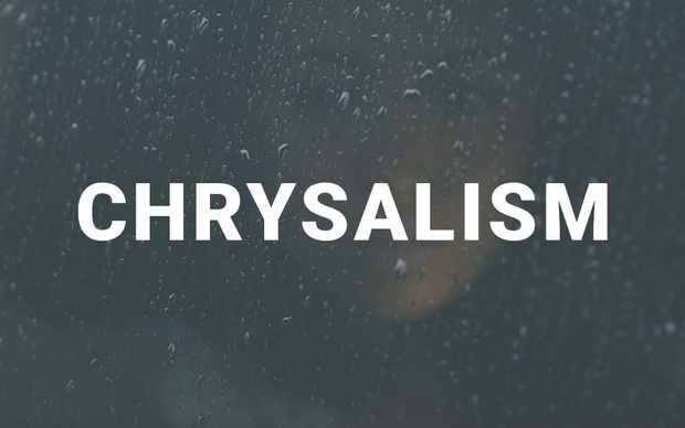 photo Raindrops on a dark window pane with a soft, blurred warm light glowing in the background, with the word 'CHRYSALISM' displayed in large white capital letters across the center of the image.