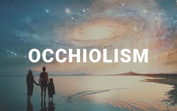 photo Silhouettes of a family — two adults and a child — holding hands on a beach shoreline, gazing up at a surreal sky filled with swirling galaxies and cosmic clouds, with the word 'OCCHIOLISM' displayed in large white capital letters across the center of the image.