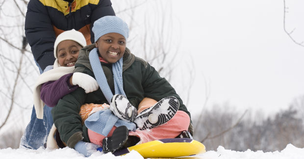 photo Children sledding together in snow.