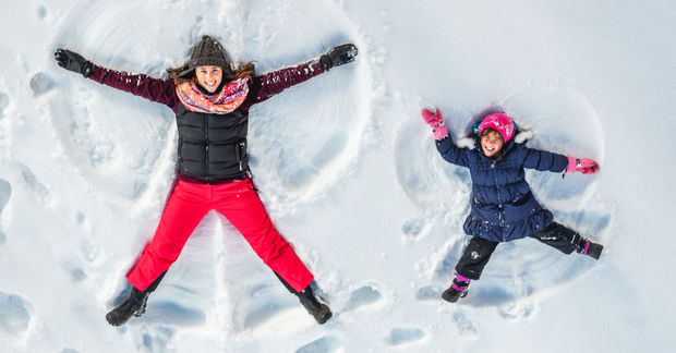 photo Two children making snow angels in snow.