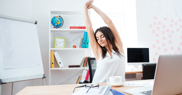 photo woman stretching on a chair in an office