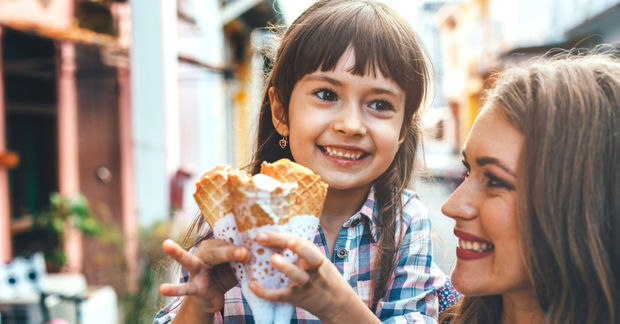 photo Mother and child sharing ice cream cone outdoors.