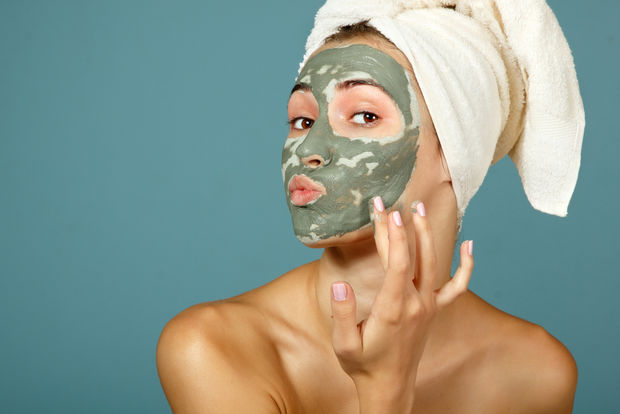 Woman putting a face mask with tea leaves