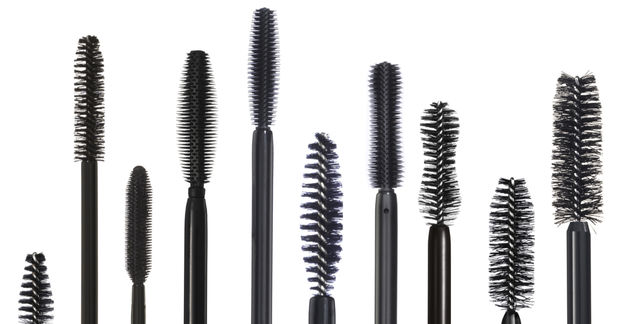 photo A row of various mascara wand brushes in different shapes and sizes displayed against a white background.