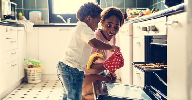 photo Couple embracing while baking in kitchen.