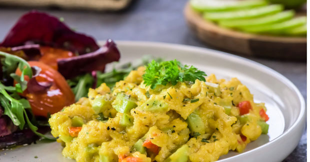 Want Plate of turmeric-spiced scrambled eggs with peppers and herbs, served with beetroot and green vegetable salad.