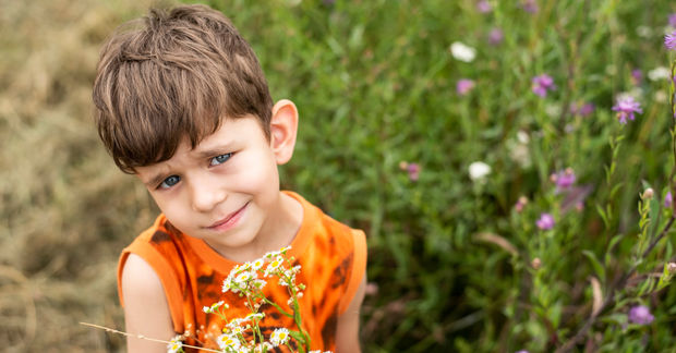 Boy Boy giving mom flowers.