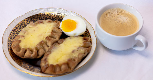 Cup Cup of coffee and Traditional Finnish Karelian pies on a plate.