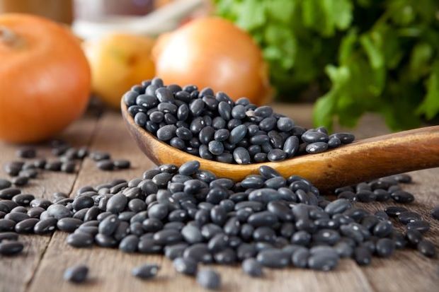 Black beans scattered on a table.