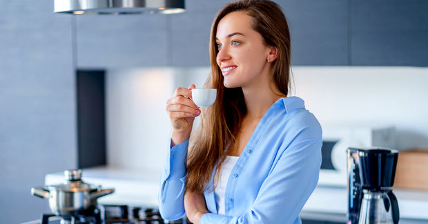 Happy Happy woman enjoying a freshly brewed espresso.