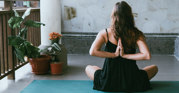 Woman Woman doing the reversed prayer yoga pose.